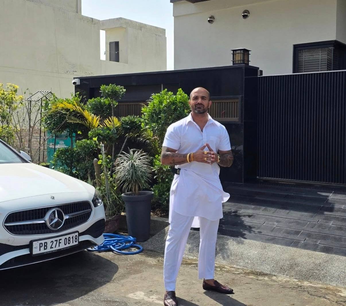 Karan Dhawan in traditional white attire and luxury villa